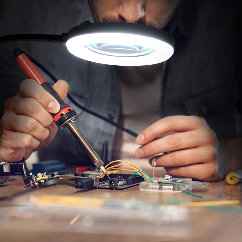 Magnifying lamp clamped to a desk